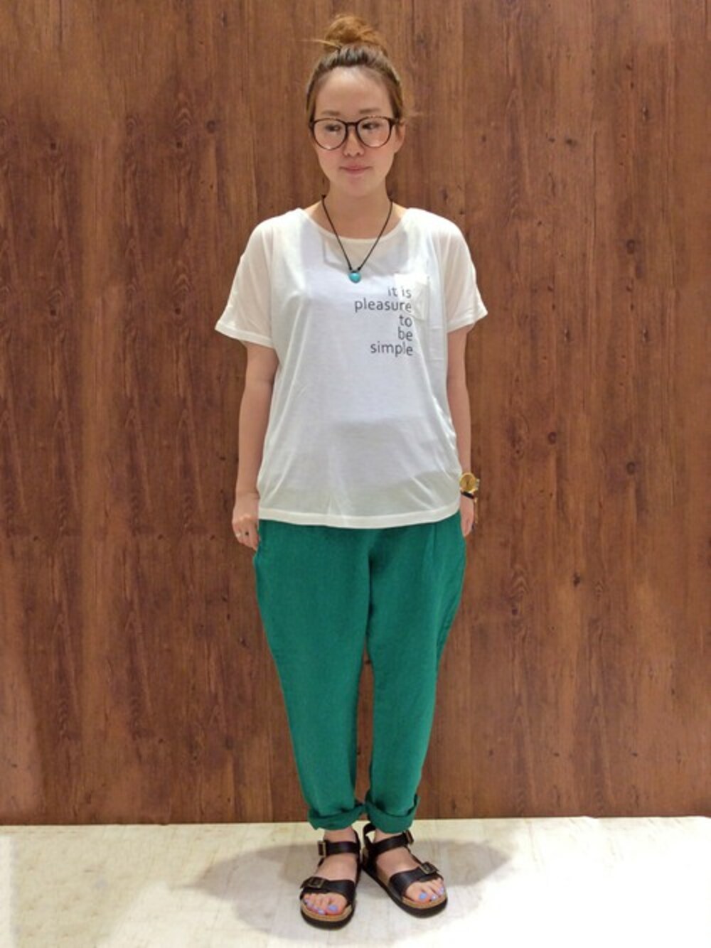 グリーン系のその他パンツ、ホワイト系のTシャツ/カットソー、ブラウン系のサンダルを着用したレディースの夏コーディネートの1枚目の写真