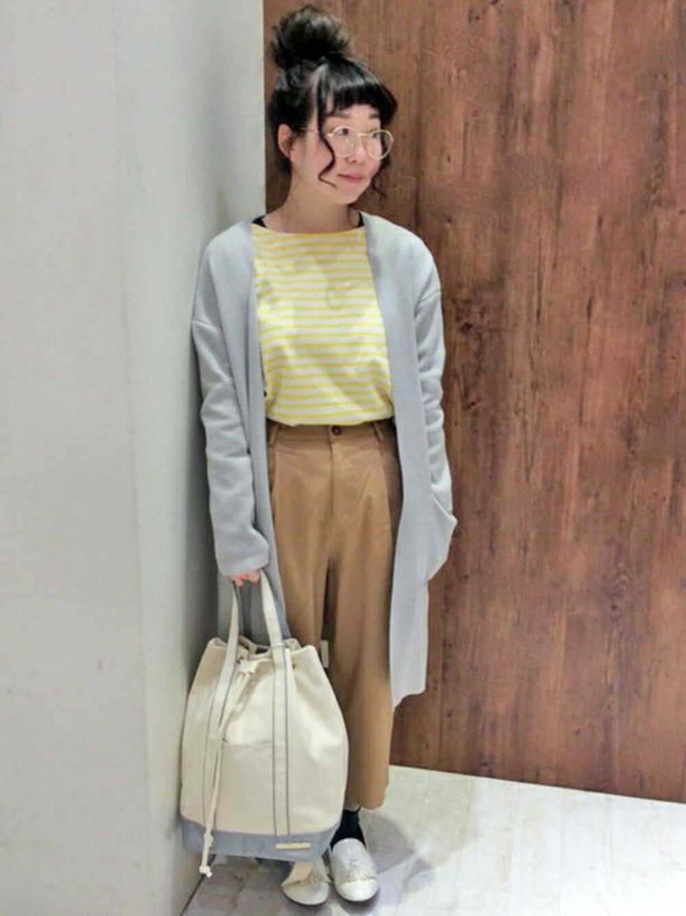 イエロー系のTシャツ/カットソー、ベージュ系のその他パンツ、グレー系のカーディガン/ボレロを着用したレディースの冬コーディネートの1枚目の写真