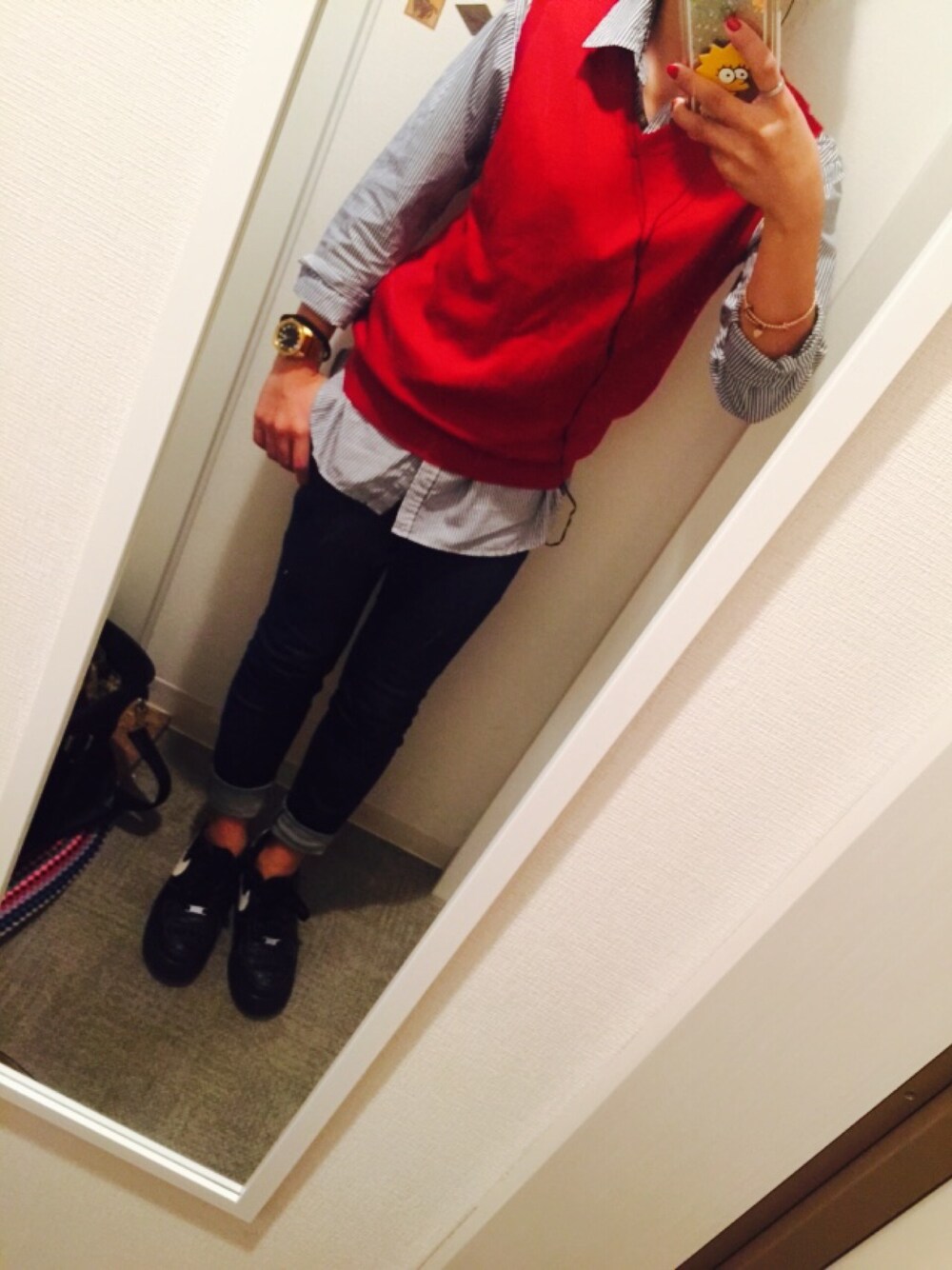 レッド系のベストを着用したレディースの秋コーディネートの1枚目の写真