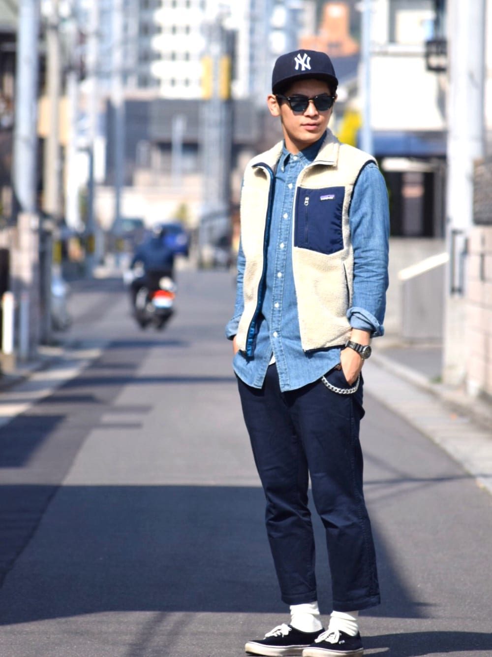 ブルー系のチノパンツ、ブルー系のスニーカー、ベージュ系のベストを着用したメンズの春コーディネートの1枚目の写真