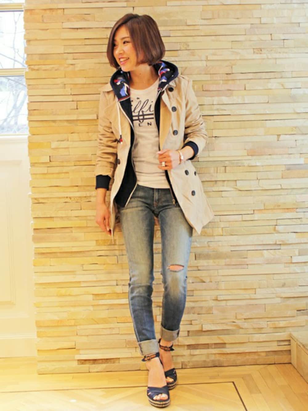ベージュ系のトレンチコート、ブルー系のデニムパンツ、その他のパーカーを着用したレディースの春コーディネートの1枚目の写真