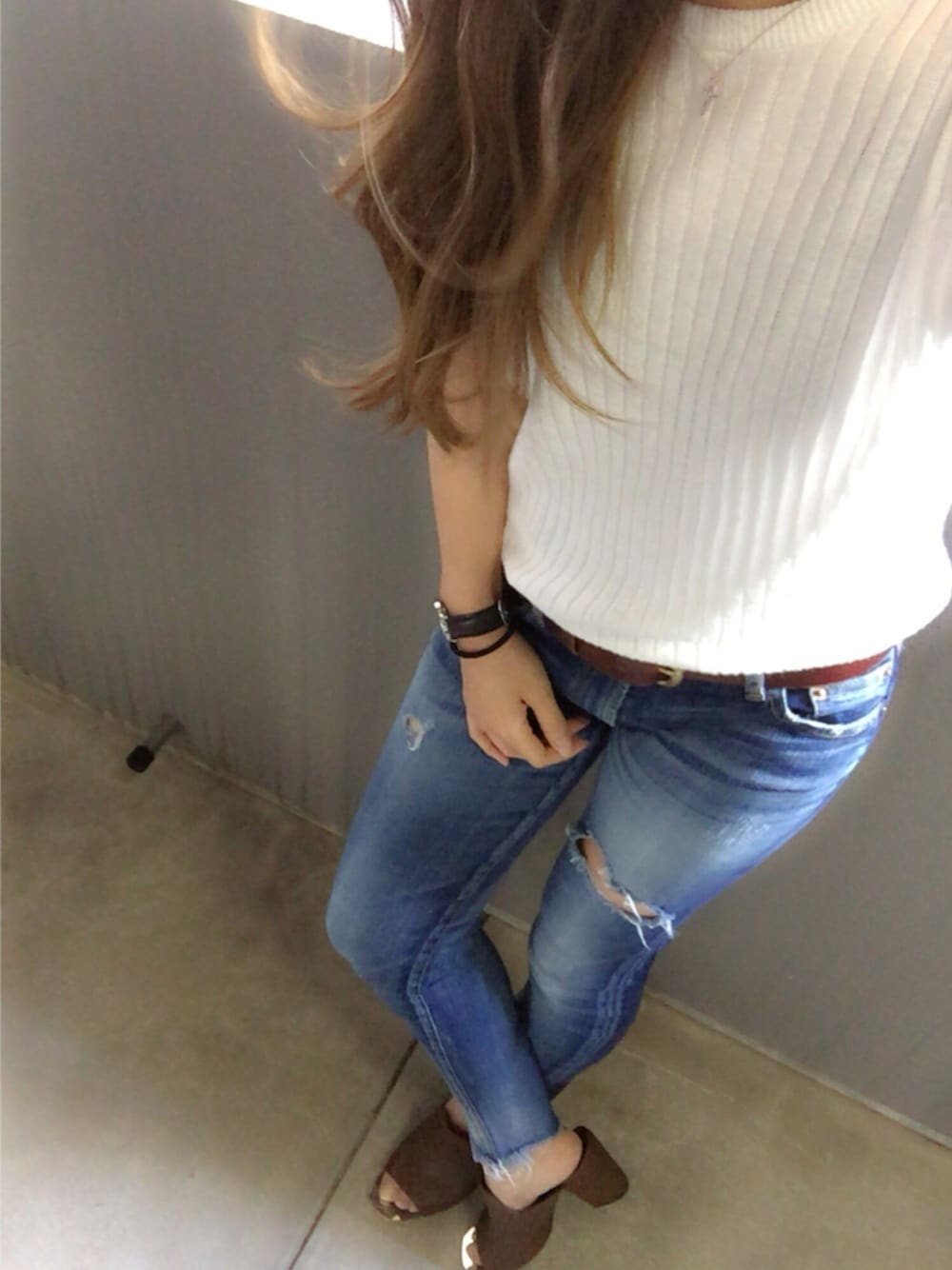 ブルー系のデニムパンツ、ブラウン系のサンダル、ホワイト系のニット/セーターを着用したレディースの春コーディネートの1枚目の写真