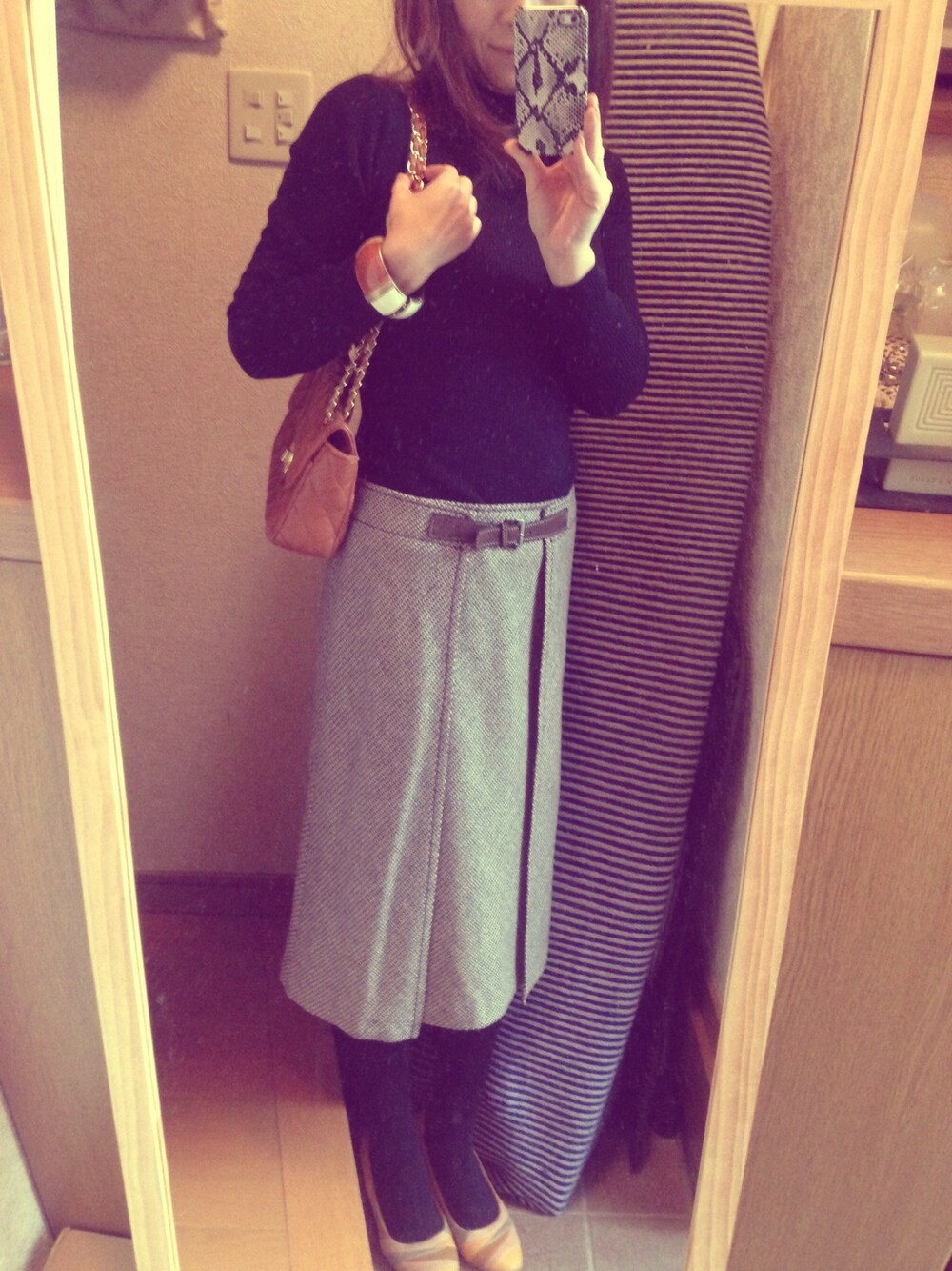 ブルー系のニット/セーター、ブラウン系のスカートを着用したレディースの冬コーディネートの1枚目の写真