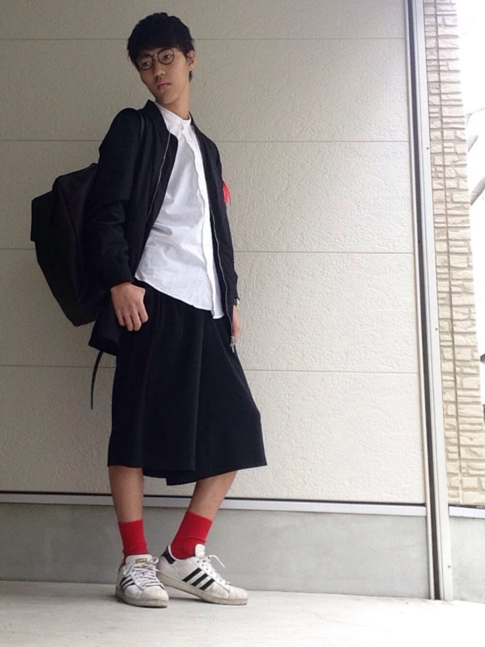 ホワイト系のスニーカー、ブラック系のその他パンツ、ブラック系のバックパック/リュックを着用したメンズの春コーディネートの1枚目の写真