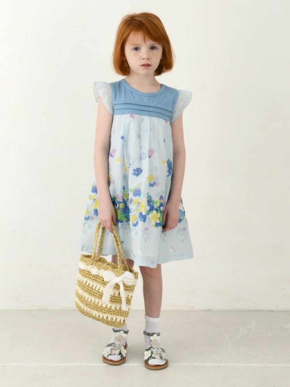 ブルー系のワンピース、ベージュ系のトートバッグ、ブラック系のサンダルを着用したキッズの夏コーディネートの1枚目の写真