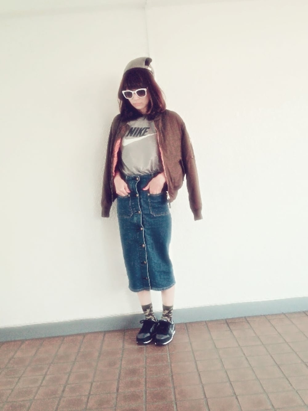 グレー系のTシャツ/カットソー、グリーン系のブルゾン、ブルー系のデニムスカートを着用したレディースの秋コーディネートの1枚目の写真