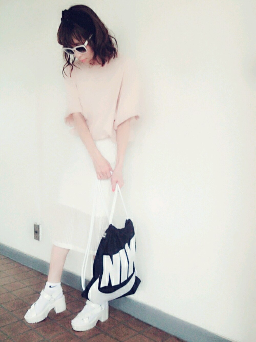 ブラック系のバックパック/リュック、ホワイト系のサンダル、ピンク系のトップスを着用したレディースの夏コーディネートの1枚目の写真