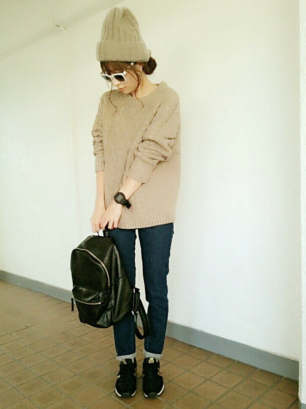 ベージュ系のトップス、ブラック系のシューズ、ブルー系のデニムパンツを着用したレディースの秋コーディネートの1枚目の写真