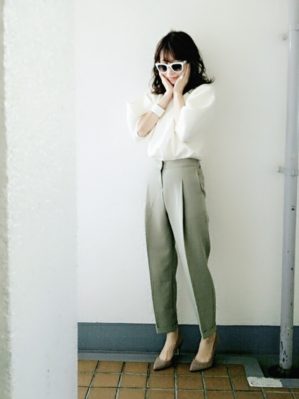 ホワイト系のニット/セーター、グリーン系のその他パンツ、ベージュ系のパンプスを着用したレディースの冬コーディネートの1枚目の写真