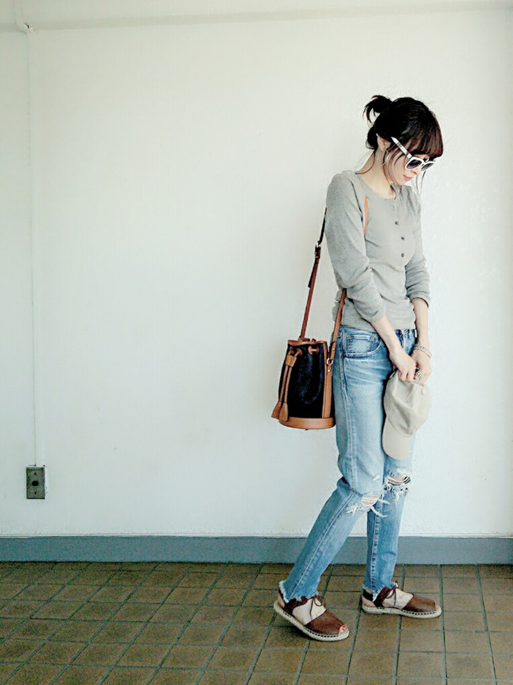 グレー系のTシャツ/カットソー、ブルー系のデニムパンツ、ブラック系のショルダーバッグを着用したレディースの春コーディネートの1枚目の写真