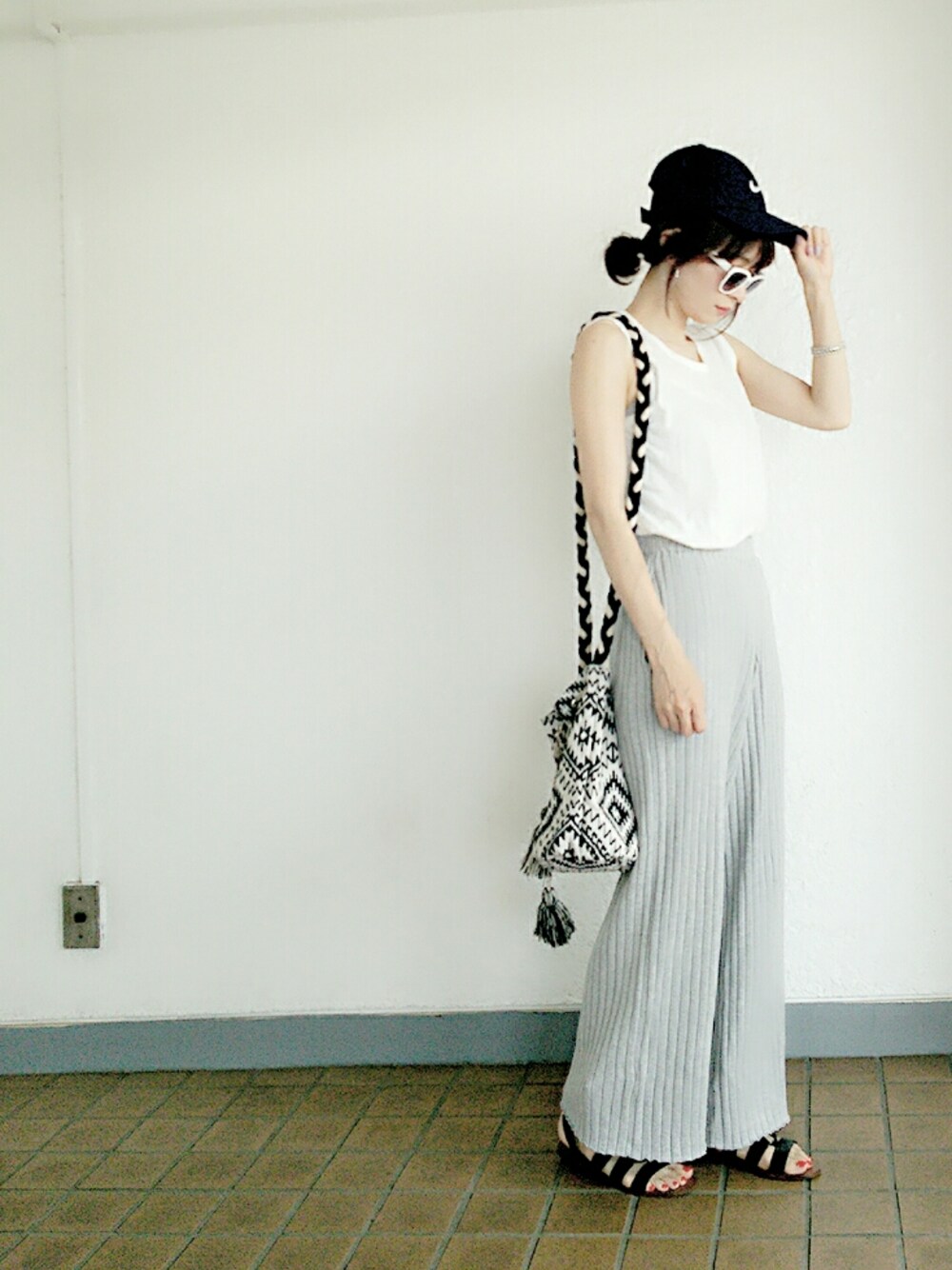 ホワイト系のタンクトップ、ブラック系のその他シューズ、グレー系のその他パンツを着用したレディースの春コーディネートの1枚目の写真