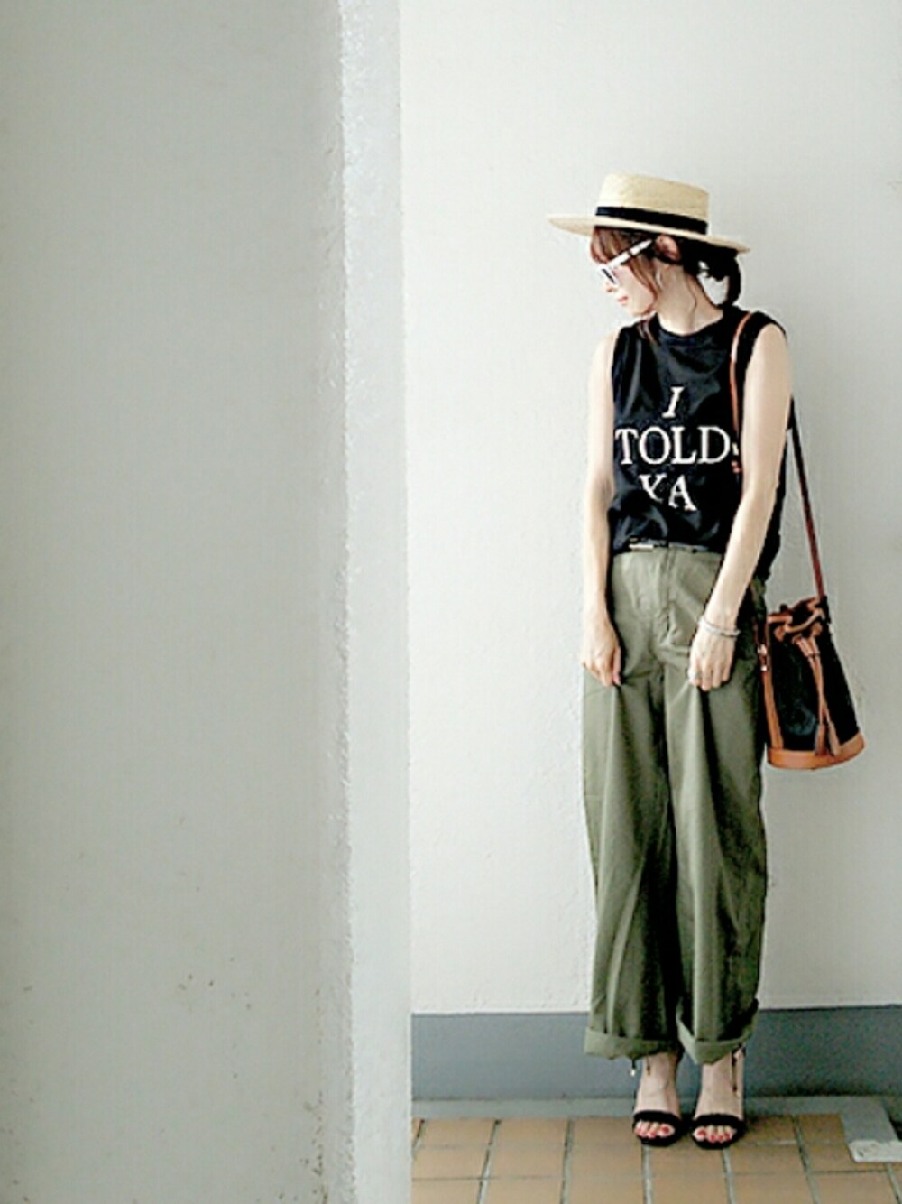 ブラック系のTシャツ/カットソー、グリーン系のチノパンツ、ブラック系のサンダルを着用したレディースの夏コーディネートの1枚目の写真