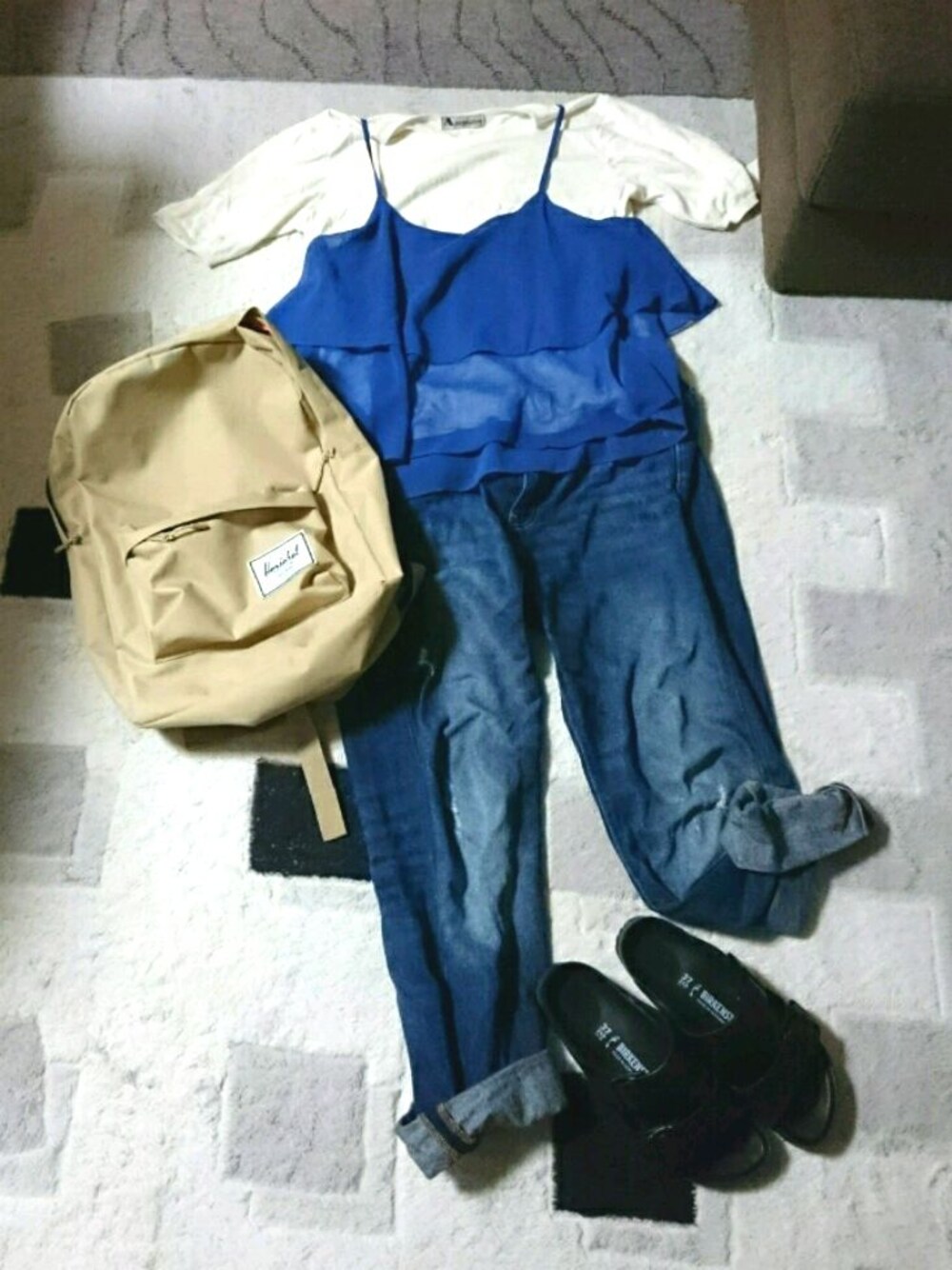 ホワイト系のTシャツ/カットソー、ブルー系のキャミソール、ベージュ系のバックパック/リュックを着用したレディースの春コーディネートの1枚目の写真