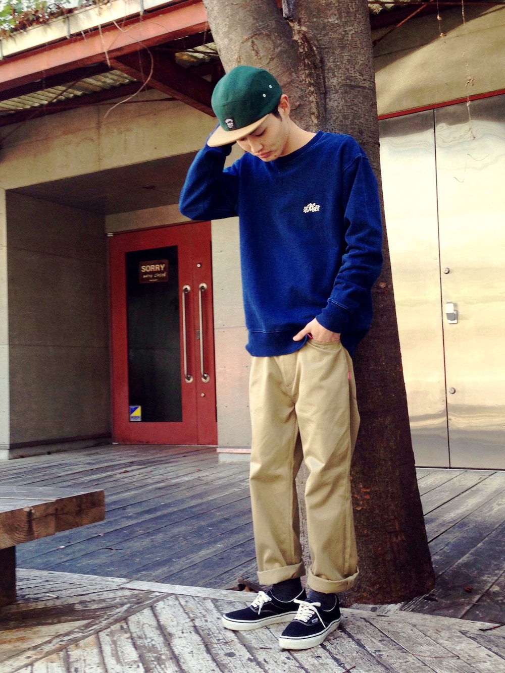 ベージュ系のチノパンツ、ブルー系のスウェット、ブラック系のスニーカーを着用したメンズの冬コーディネートの1枚目の写真