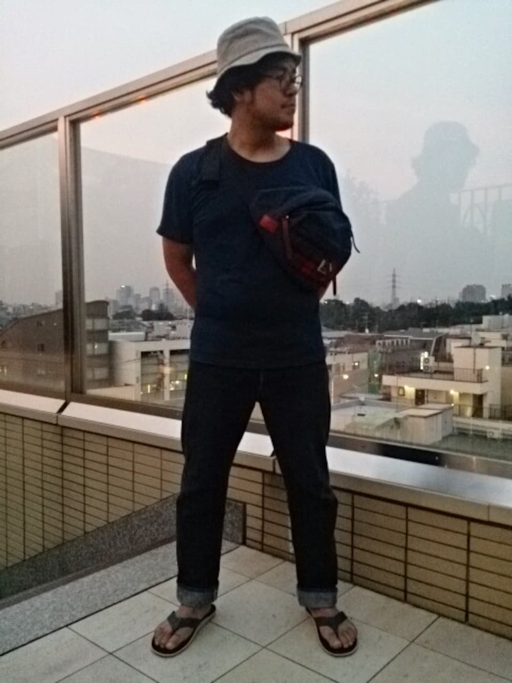 ブルー系のデニムパンツ、ブルー系のサンダル、ブルー系のTシャツ/カットソーを着用したメンズの夏コーディネートの1枚目の写真
