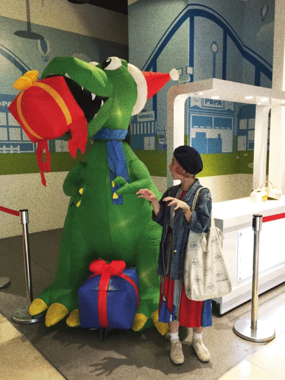 レッド系のワンピース、ベージュ系のショルダーバッグ、ブルー系のその他を着用したレディースの秋コーディネートの1枚目の写真