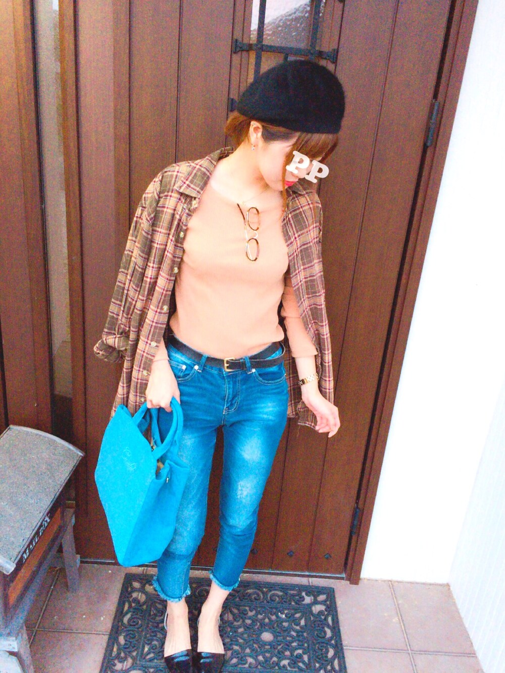 オレンジ系のニット/セーター、ブルー系のデニムパンツ、ブラック系のパンプスを着用したレディースの秋コーディネートの1枚目の写真