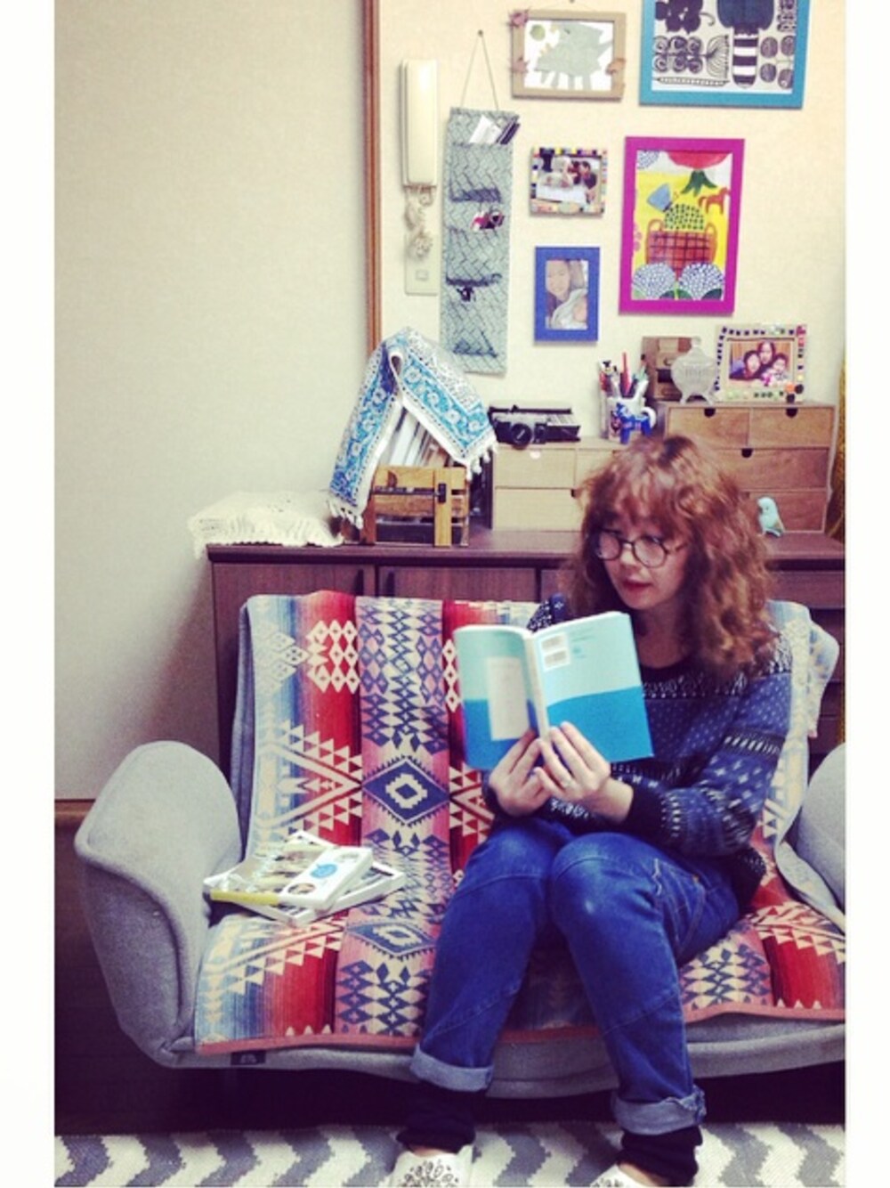 ブルー系のニット/セーター、ブルー系のデニムパンツ、その他の本を着用したレディースの冬コーディネートの1枚目の写真