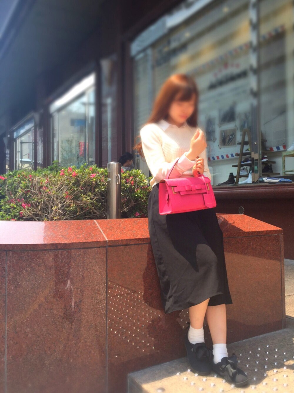 ピンク系のハンドバッグ、ブラック系のパンツ、ホワイト系のニット/セーターを着用したレディースの春コーディネートの1枚目の写真