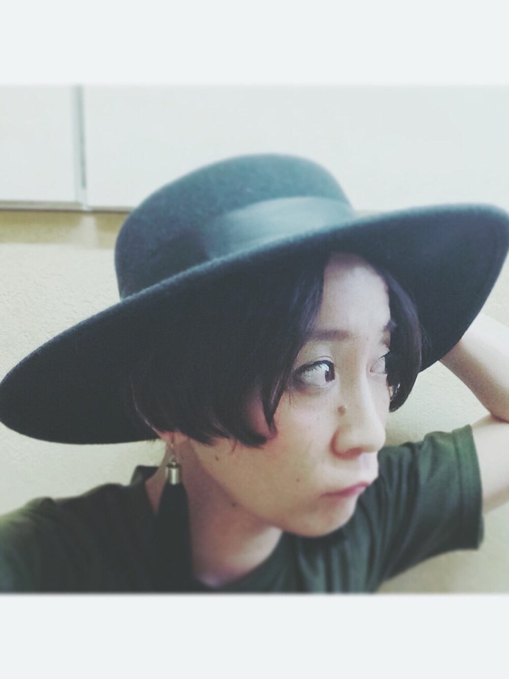 グリーン系のTシャツ/カットソー、ブラック系のハット、ブラック系のピアス（両耳用）を着用したレディースの秋コーディネートの1枚目の写真