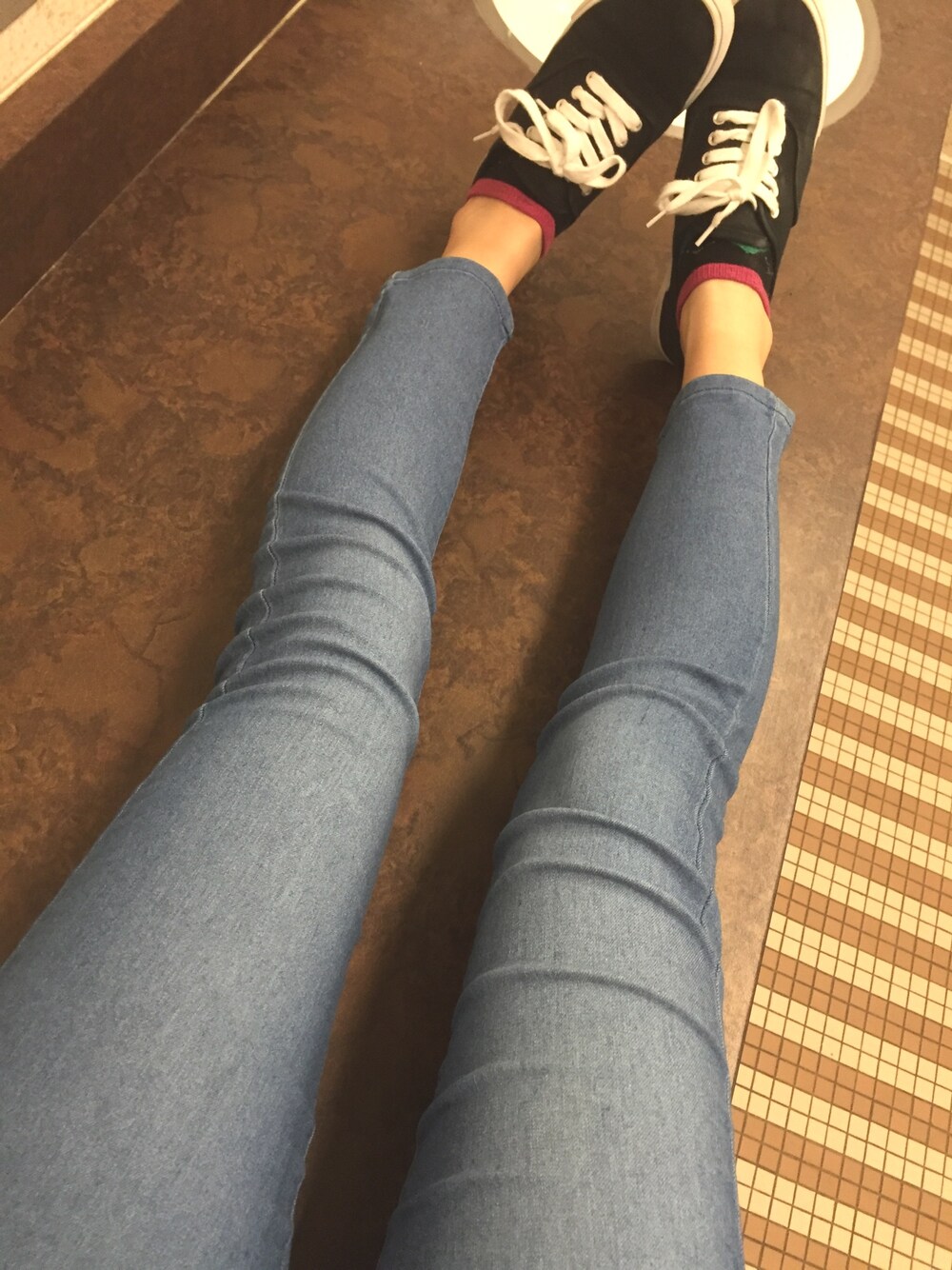 ブラック系のデニムパンツ、ホワイト系のスニーカーを着用したレディースの春コーディネートの1枚目の写真