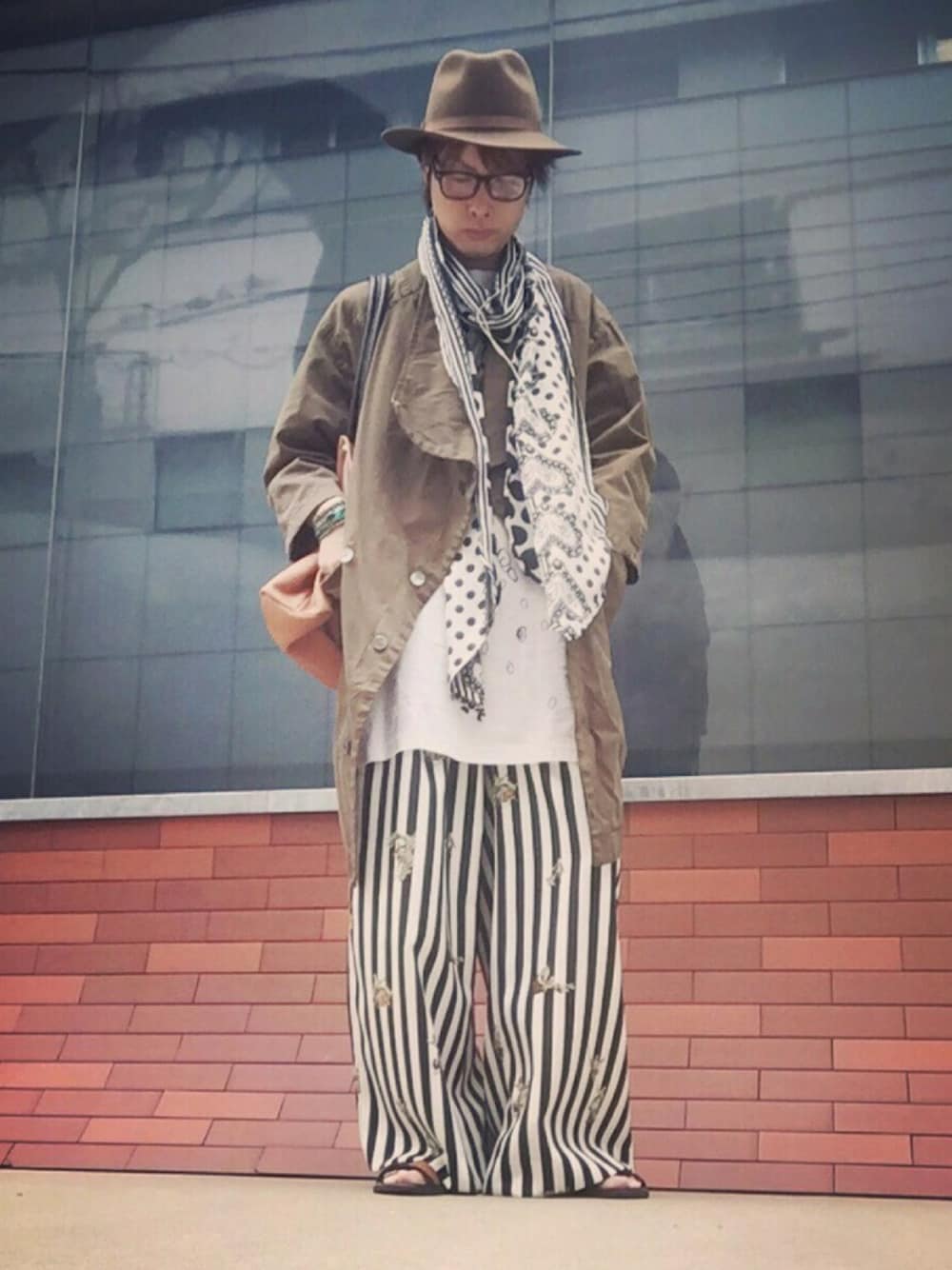 グリーン系のトレンチコート、ホワイト系のワンピース、その他のその他パンツを着用したメンズの秋コーディネートの1枚目の写真