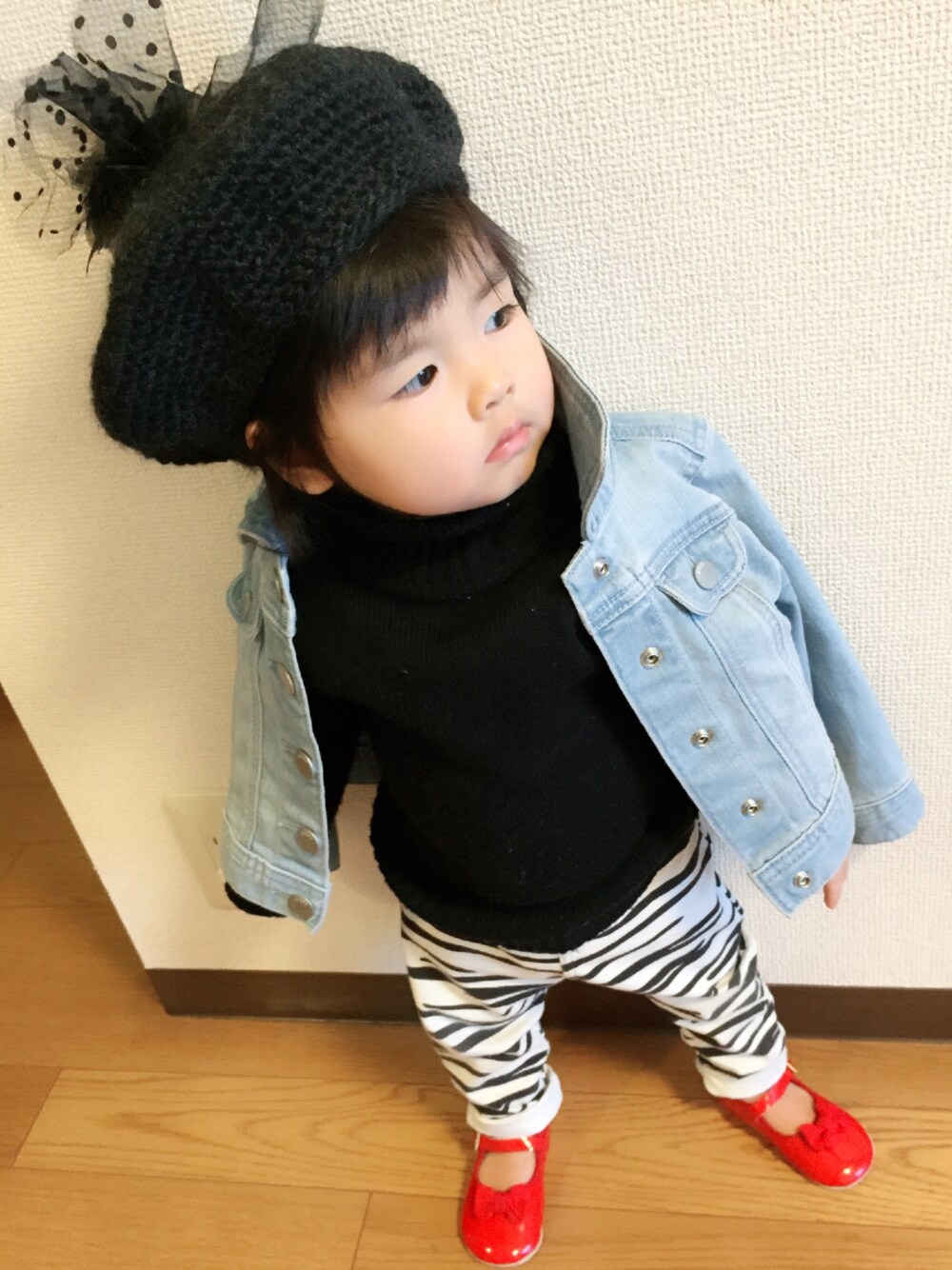 ブラック系のニット/セーター、ブルー系のデニムジャケット、ホワイト系のパンツを着用したキッズの冬コーディネートの1枚目の写真