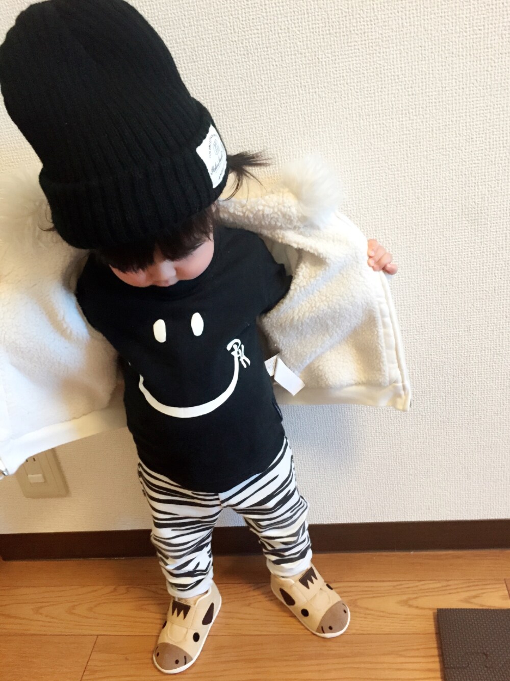 ホワイト系のパーカー、ブラック系のTシャツ/カットソー、ホワイト系のパンツを着用したキッズの冬コーディネートの1枚目の写真