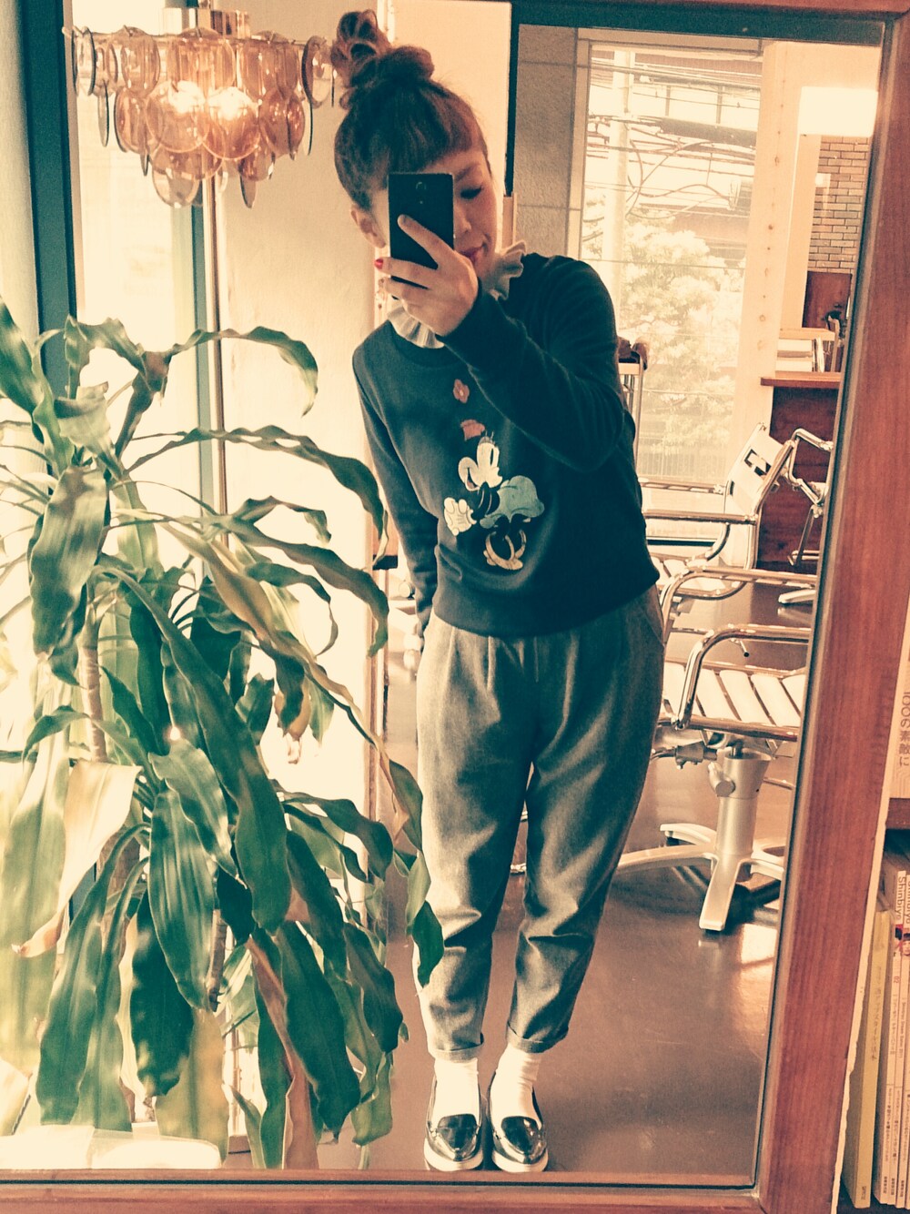 グレー系のニット/セーター、ブルー系のTシャツ/カットソー、グレー系のスラックスを着用したレディースの冬コーディネートの1枚目の写真