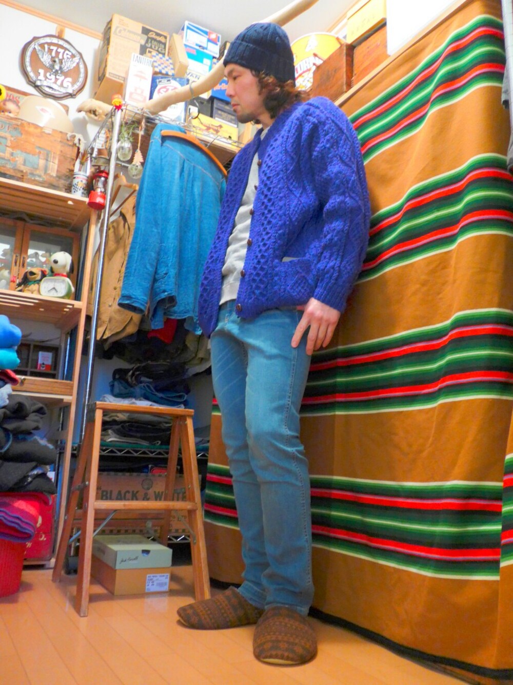 ブルー系のニット/セーター、グレー系のスウェット、ブルー系のデニムパンツを着用したメンズの冬コーディネートの1枚目の写真