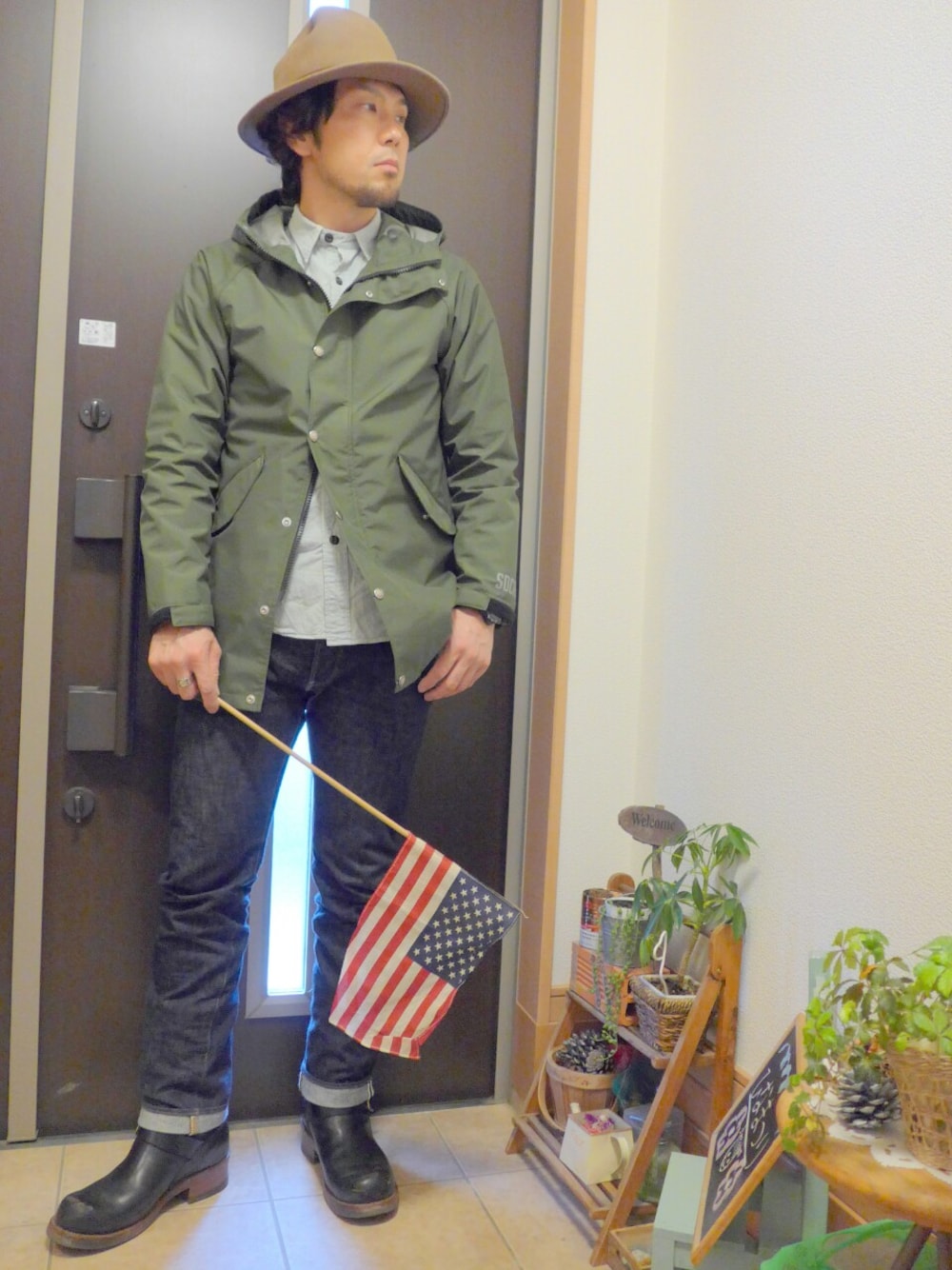 グリーン系のマウンテンパーカー、ブルー系のシャツ/ブラウス、ブルー系のデニムパンツを着用したメンズの冬コーディネートの1枚目の写真