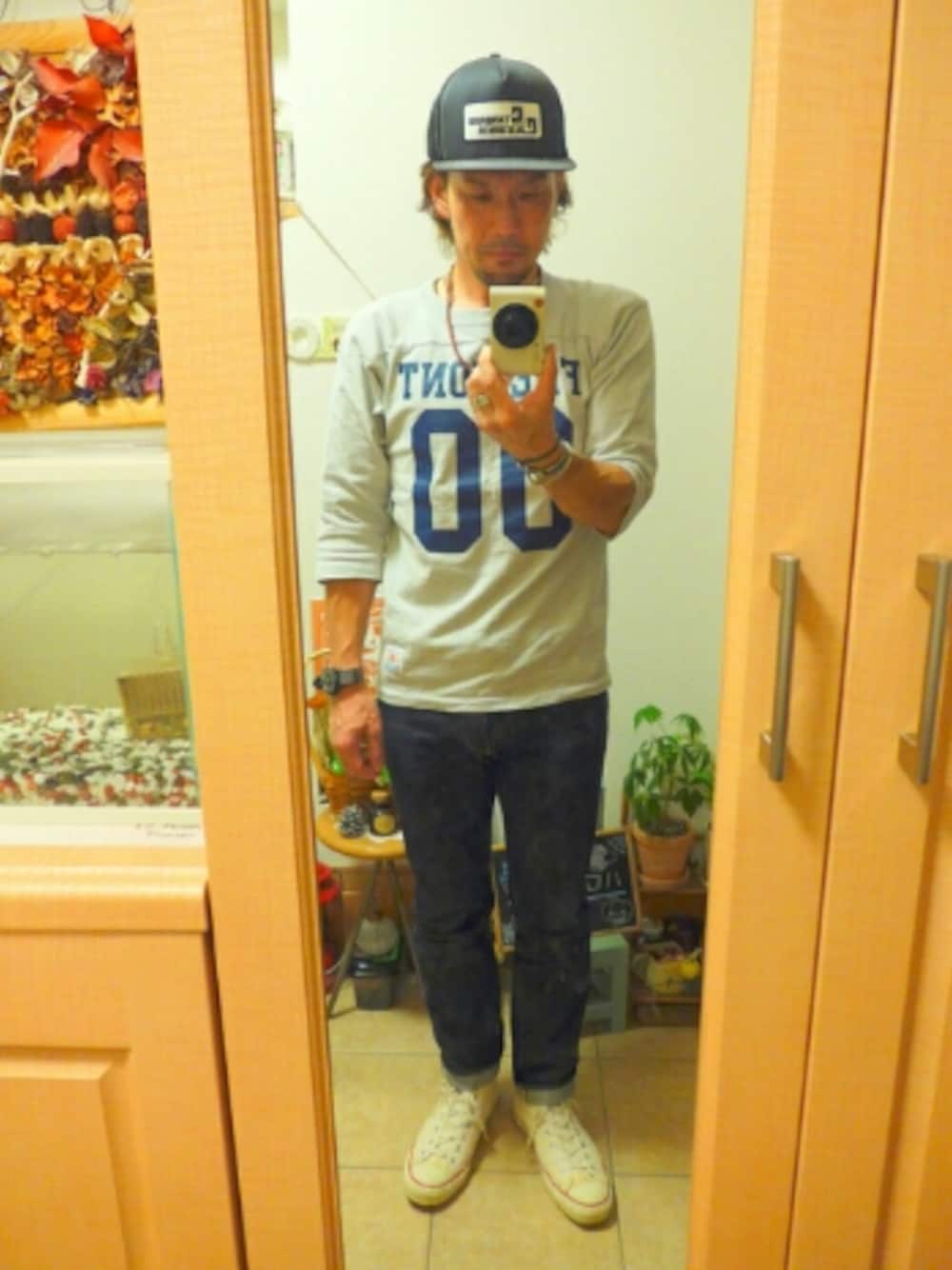 グレー系のTシャツ/カットソー、ブルー系のデニムパンツ、ホワイト系のシューズを着用したメンズの秋コーディネートの1枚目の写真