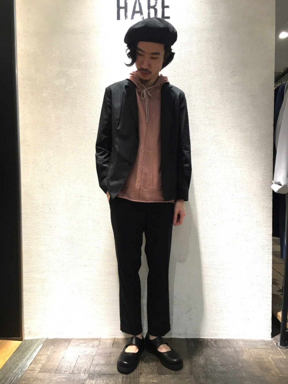 グレー系のスラックス、ブラック系のスニーカー、ブラック系のテーラードジャケットを着用したメンズの春コーディネートの1枚目の写真