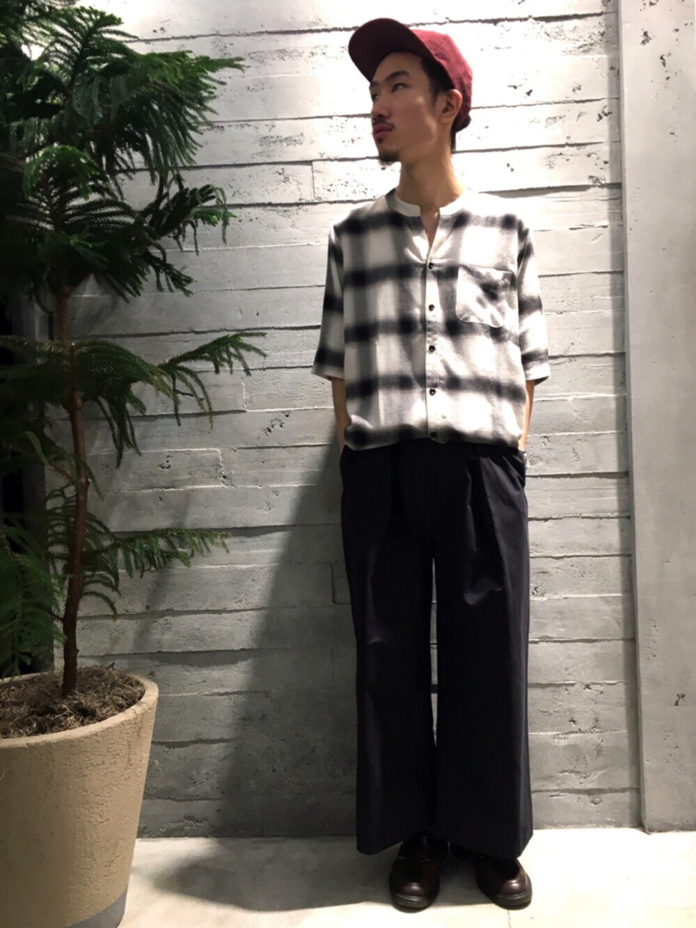 ホワイト系のトップス、ブラウン系のシューズ、ブラック系のスラックスを着用したメンズの夏コーディネートの1枚目の写真