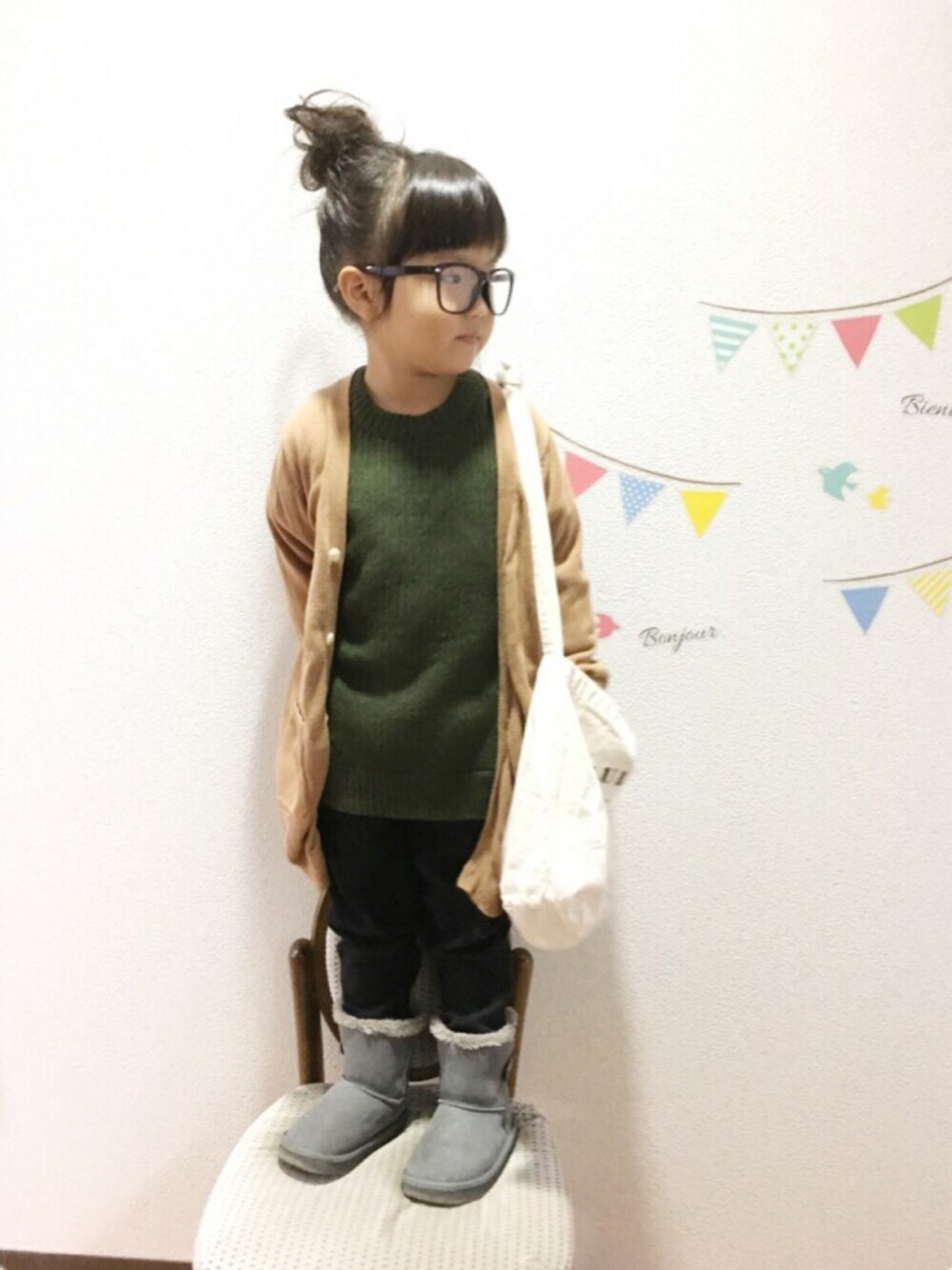 グリーン系のニット/セーター、ベージュ系のカーディガン/ボレロ、ブラック系のその他パンツを着用したキッズの秋コーディネートの1枚目の写真