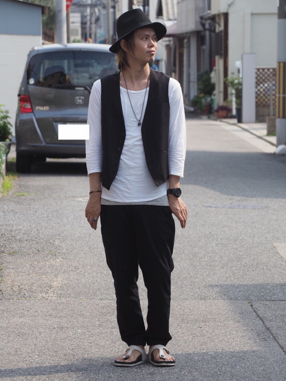 ホワイト系のTシャツ/カットソー、ブラック系のベスト、ブラック系のサンダルを着用したメンズの夏コーディネートの1枚目の写真