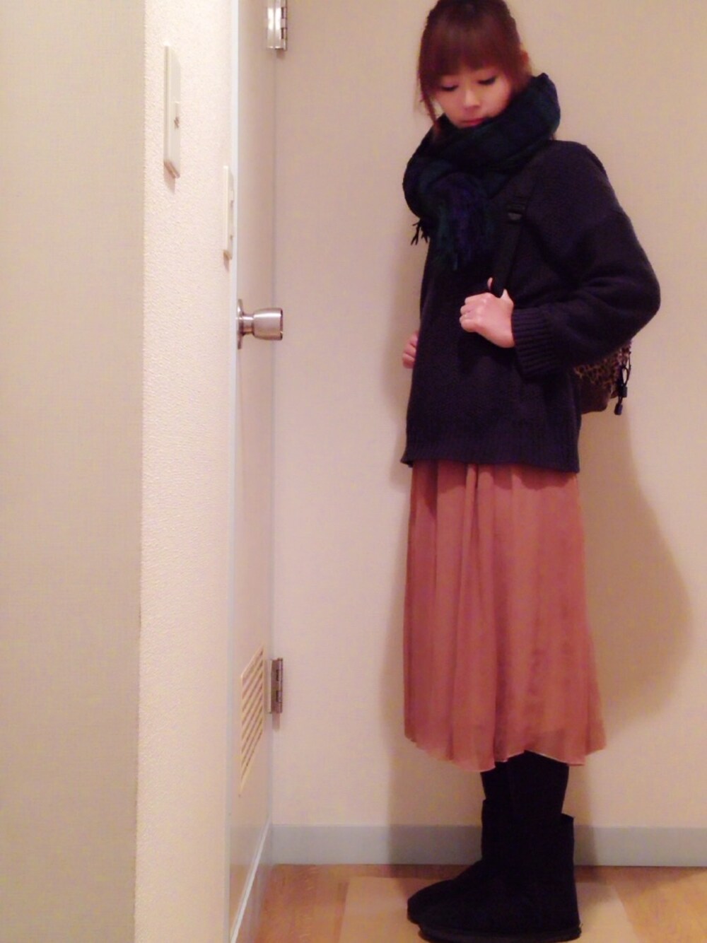 ブルー系のニット/セーター、ブラウン系のスカート、ブラック系のブーツを着用したレディースの冬コーディネートの1枚目の写真