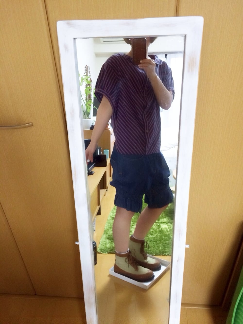 ベージュ系のブーツ、ブルー系のトップス、ブルー系のデニムパンツを着用したレディースの春コーディネートの1枚目の写真