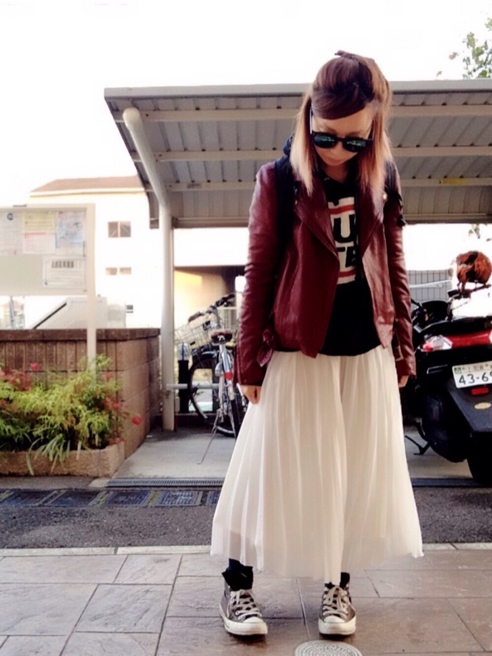 ブラック系のパーカー、ホワイト系のスカート、レッド系のライダースジャケットを着用したレディースの秋コーディネートの1枚目の写真