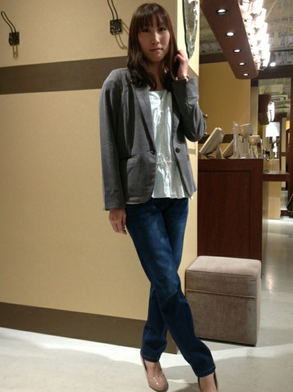 グレー系のテーラードジャケット、ホワイト系のシャツ/ブラウス、ブルー系のデニムパンツを着用したレディースの春コーディネートの1枚目の写真