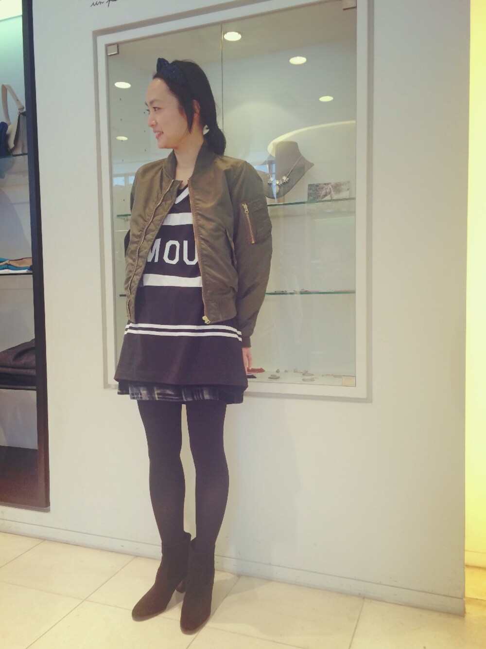 グリーン系のミリタリージャケットを着用したレディースの冬コーディネートの1枚目の写真