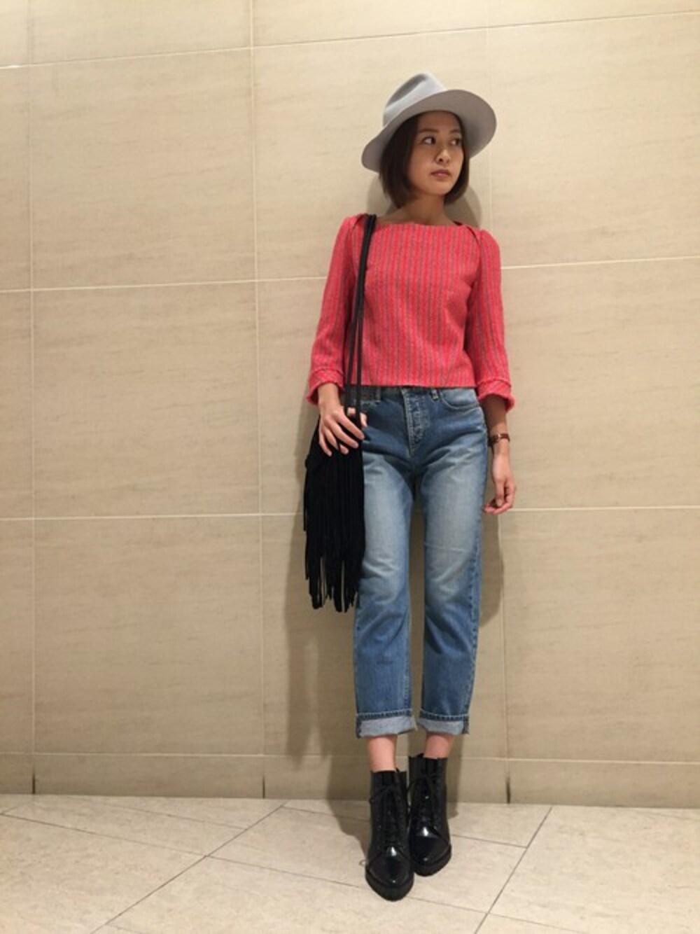 ピンク系のTシャツ/カットソー、ブルー系のデニムパンツ、ブラック系のブーツを着用したレディースの秋コーディネートの1枚目の写真