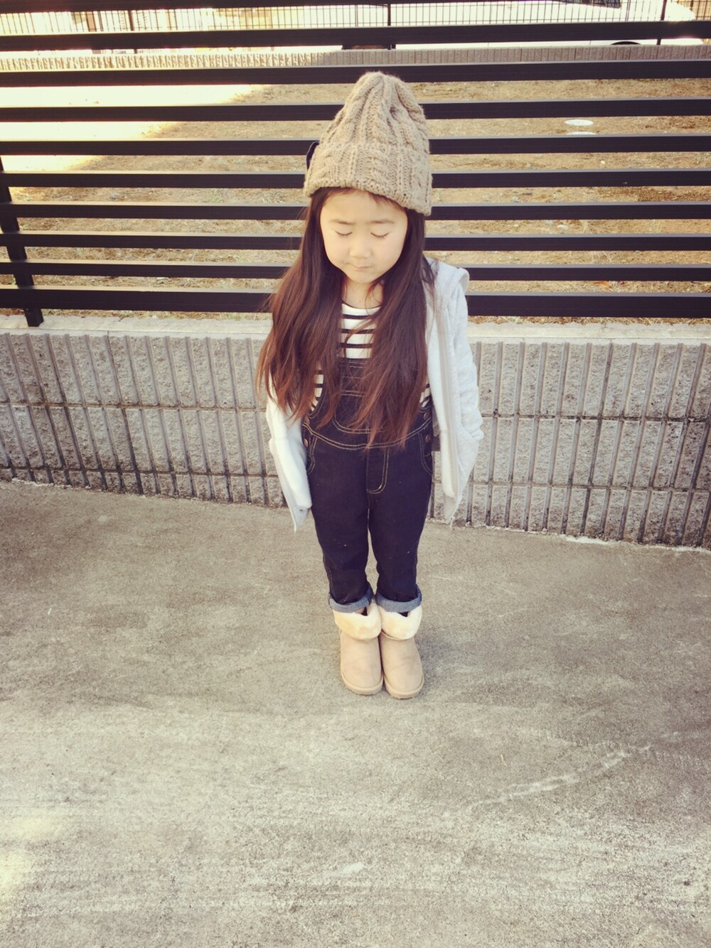 ブルー系のサロペット/オーバーオール、ベージュ系のブーツ、その他のその他トップスを着用したキッズの冬コーディネートの1枚目の写真