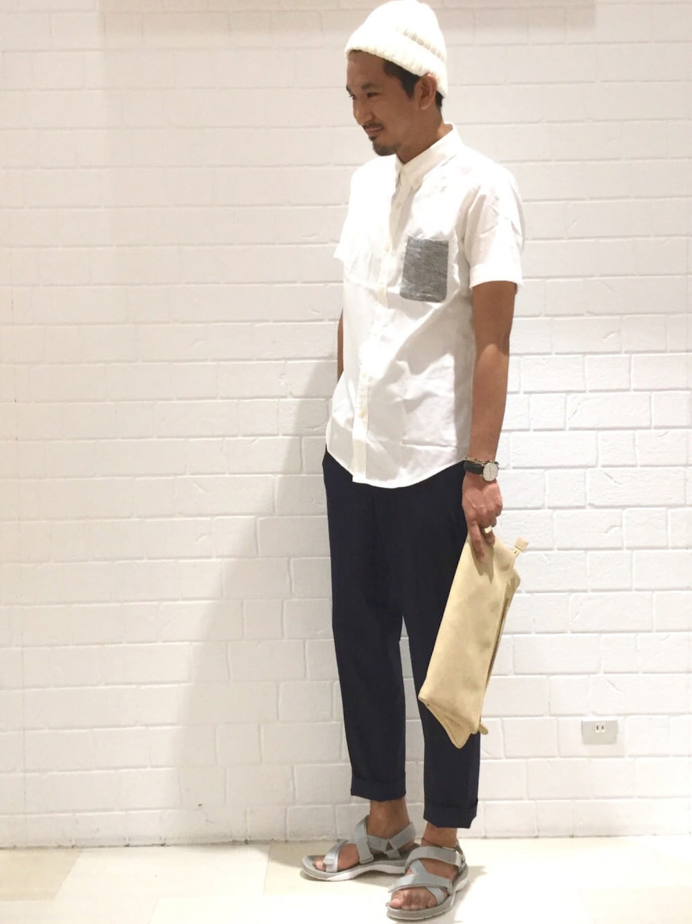 ブルー系のその他パンツ、グレー系のサンダル、ベージュ系のクラッチバッグを着用したメンズの夏コーディネートの1枚目の写真