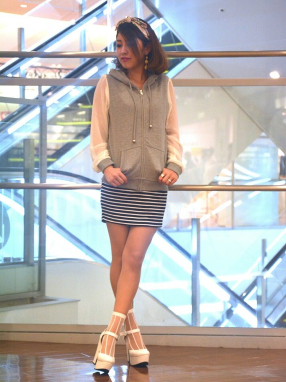 グレー系のパーカー、ブラック系のスカート、ホワイト系のカチューシャを着用したレディースの春コーディネートの1枚目の写真