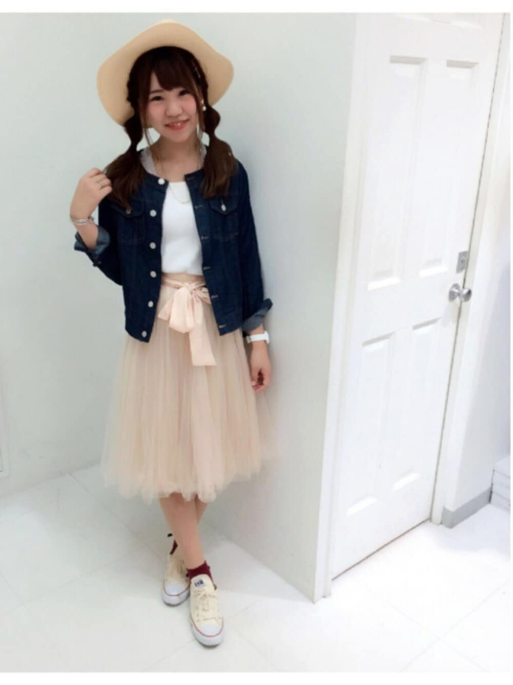 ブルー系のテーラードジャケット、ホワイト系のTシャツ/カットソー、ベージュ系のスカートを着用したレディースの春コーディネートの1枚目の写真