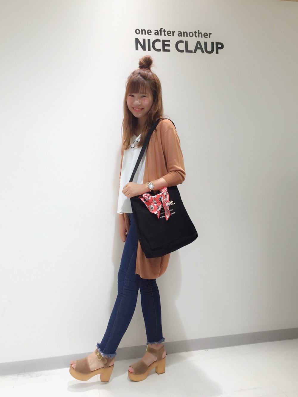 ブラック系のトートバッグ、ブラウン系のカーディガン/ボレロ、ホワイト系のシャツ/ブラウスを着用したレディースの春コーディネートの1枚目の写真