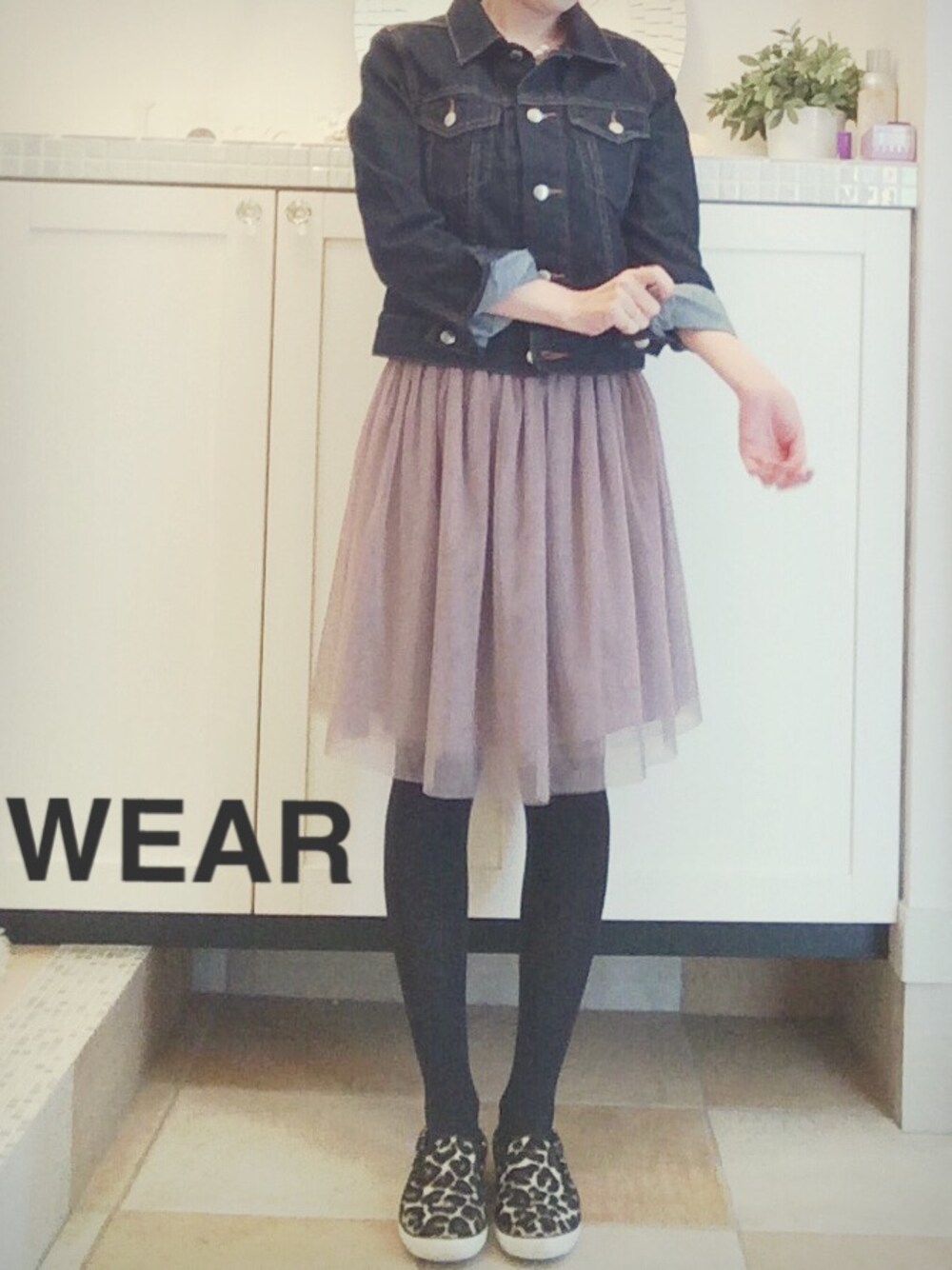 ブルー系のデニムジャケット、ブラック系のスニーカー、ブラック系のタイツ/ストッキングを着用したレディースの冬コーディネートの1枚目の写真