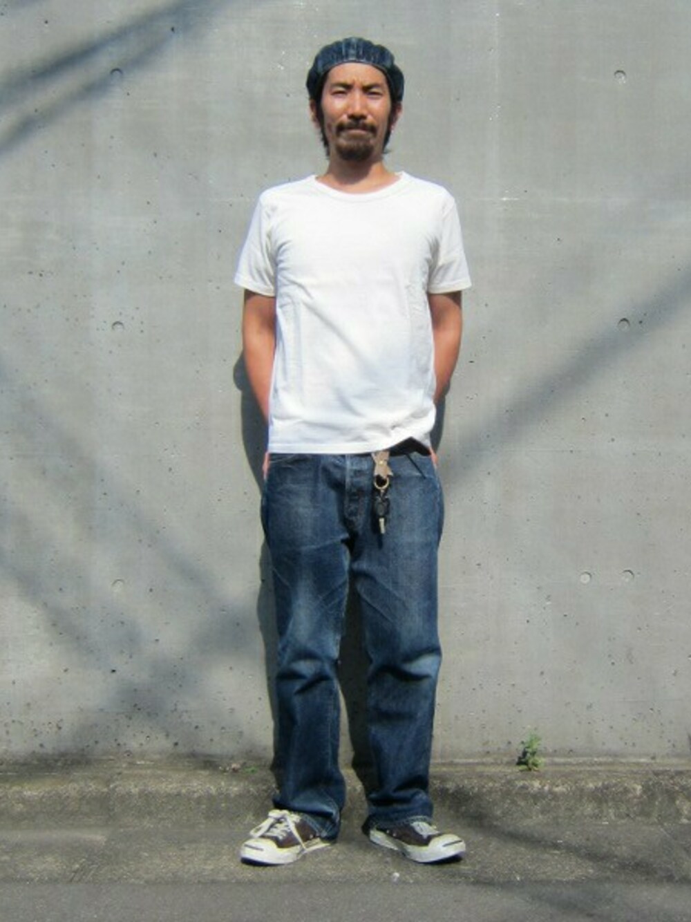 ブルー系のデニムパンツ、ホワイト系のTシャツ/カットソーを着用したメンズの夏コーディネートの1枚目の写真