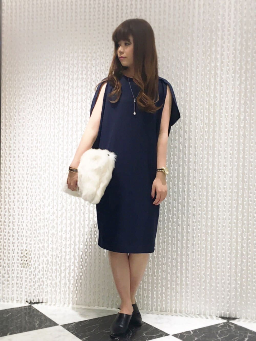 ブルー系のワンピース、ホワイト系のクラッチバッグ、ブラック系のシューズを着用したレディースの秋コーディネートの1枚目の写真